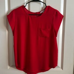 Red lightweight blouse with pocket in the front.